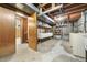 Unfinished basement with storage shelves, utility sink, and laundry hookups at 8198 E Lehigh Dr, Denver, CO 80237