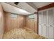 Basement area with carpet flooring, wood paneling, and a closet at 8198 E Lehigh Dr, Denver, CO 80237