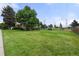 Spacious front yard with lush lawn and mature trees, enhancing the home's curb appeal at 8198 E Lehigh Dr, Denver, CO 80237