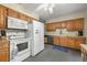 Traditional kitchen featuring wood cabinets, white appliances, and a ceiling fan at 8198 E Lehigh Dr, Denver, CO 80237