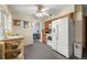 Cozy kitchen leading to a dining area, showcasing ample counter space and a refrigerator at 8198 E Lehigh Dr, Denver, CO 80237