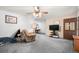 Bright living room with neutral carpeting, a ceiling fan, and comfortable seating arrangements at 8198 E Lehigh Dr, Denver, CO 80237