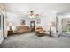 Cozy living room with neutral carpeting, ceiling fan, and comfortable seating at 8198 E Lehigh Dr, Denver, CO 80237
