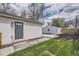 View of backyard featuring a detached garage, concrete patio, and landscaped yard at 4874 S Lincoln St, Englewood, CO 80113