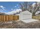 A detached one-car garage with a fresh coat of white paint, sitting next to a new stained wood fence at 4874 S Lincoln St, Englewood, CO 80113
