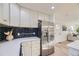 Kitchen features stainless refrigerator, quartz countertops, subway tile backsplash, and hardwood floors at 4874 S Lincoln St, Englewood, CO 80113