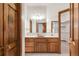 A traditional bathroom with a vanity, mirrors, and access to a walk-in closet and shower at 103 Red Wing Ct, Mead, CO 80542