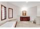 Bright bathroom with bathtub, tile flooring, vanity, and a separate toilet area at 103 Red Wing Ct, Mead, CO 80542