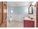 Powder room with red vanity, framed mirror, and decorative wall paneling at 103 Red Wing Ct, Mead, CO 80542