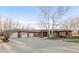 Expansive brick home with a wide driveway and three-car garage, complemented by mature trees at 103 Red Wing Ct, Mead, CO 80542