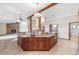 Open kitchen area with a large island, wooden beams, and views into the living room and dining space at 103 Red Wing Ct, Mead, CO 80542