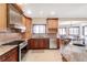 Well-lit kitchen featuring tile flooring, stainless steel appliances, and wooden cabinets at 103 Red Wing Ct, Mead, CO 80542