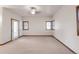 Airy living room featuring neutral paint and carpet, a ceiling fan and many windows at 103 Red Wing Ct, Mead, CO 80542