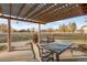The covered patio features a dining table and chairs with views of mature landscaping at 103 Red Wing Ct, Mead, CO 80542