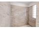 An expansive shower with granite walls, tiled flooring, and glass window at 103 Red Wing Ct, Mead, CO 80542