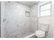 Bathroom featuring walk-in shower with marble tile, gray tiled floor and updated fixtures at 1104 S Biscay St, Aurora, CO 80017
