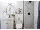 Bathroom featuring walk-in shower with marble tile, gray tiled floor and updated fixtures at 1104 S Biscay St, Aurora, CO 80017