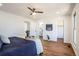 Bright bedroom features wood floors, a ceiling fan, and ensuite bathroom and closet at 1104 S Biscay St, Aurora, CO 80017