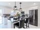Eat-in kitchen featuring black countertops, white cabinets, and a center island with barstool seating at 1104 S Biscay St, Aurora, CO 80017