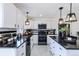 Updated kitchen with white cabinets, black countertops, stainless steel appliances, and modern lighting at 1104 S Biscay St, Aurora, CO 80017
