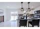 Bright kitchen features a large island with pendant lights, stainless steel appliances, and sliding glass door to backyard at 1104 S Biscay St, Aurora, CO 80017