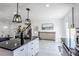 Modern kitchen with a center island, white cabinetry, dark countertops, and stylish pendant lighting at 1104 S Biscay St, Aurora, CO 80017