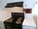 Updated kitchen with new countertops, brick fireplace view, modern backsplash and black oven range at 2215 S Buckley Rd # 201, Aurora, CO 80013
