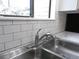 Close-up of a stainless steel kitchen sink with a modern faucet and white subway tile backsplash at 2215 S Buckley Rd # 201, Aurora, CO 80013