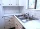 Bright kitchen with stainless steel sink, white cabinets, and tile backsplash at 2215 S Buckley Rd # 201, Aurora, CO 80013