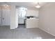 Open-concept living space with neutral carpet leading to a kitchen with white cabinets at 2215 S Buckley Rd # 201, Aurora, CO 80013