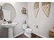 Stylish half-bathroom features a pedestal sink, modern toilet, and decorative wall art, creating a welcoming space at 4548 River Highlands Loop, Elizabeth, CO 80107