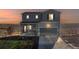 Charming two-story home with a covered porch, gray siding, manicured lawn, and mountain views at sunset at 4548 River Highlands Loop, Elizabeth, CO 80107