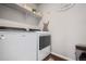 Laundry room with a new Whirlpool washer and dryer and storage shelves at 4548 River Highlands Loop, Elizabeth, CO 80107
