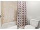 Cozy bathroom featuring a tub with neutral tiling and a decorative shower curtain at 21028 E Saratoga Ave, Aurora, CO 80015