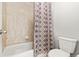 Bright bathroom with a bathtub and shower featuring stylish tile and a patterned shower curtain at 21028 E Saratoga Ave, Aurora, CO 80015