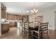 Open dining area features dark hardwood floors, a decorative chandelier and stylish table and seating at 21028 E Saratoga Ave, Aurora, CO 80015