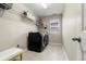 Well-lit laundry room with modern washer/dryer, storage shelves, and bright window at 21028 E Saratoga Ave, Aurora, CO 80015