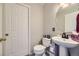 A clean half bath includes white fixtures, a pedestal sink, and wood look floors at 4708 Rock Pipit Ct, Highlands Ranch, CO 80126