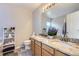 Bathroom features a dual sink vanity with granite countertops, a large mirror, and wood-look floors at 4708 Rock Pipit Ct, Highlands Ranch, CO 80126