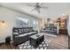 Spacious living room showing dark hardwood floors, a ceiling fan, and view into the adjacent kitchen at 4708 Rock Pipit Ct, Highlands Ranch, CO 80126