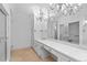 Bathroom with a large vanity, white cabinets, and decorative chandelier lighting at 5700 S Quebec St # A, Englewood, CO 80111