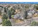 Expansive aerial view of the property showcases lush surroundings, mature trees, and mountain views at 6671 S Hill Way, Littleton, CO 80120