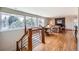 Open-concept living room with hardwood floors, large windows, and a staircase with metal railings at 6671 S Hill Way, Littleton, CO 80120