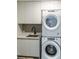 Bright laundry room features a Whirlpool washer and dryer, sink, and modern white cabinets at 1901 Wazee St # 1020, Denver, CO 80202