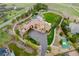 Aerial view of estate showcasing pool, hot tub, tennis court, putting green, water feature, and sprawling grounds at 8417 High Ridge Ct, Castle Pines, CO 80108