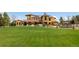 Expansive backyard featuring a well-manicured lawn, landscaping, and an elegant Mediterranean-style home at 8417 High Ridge Ct, Castle Pines, CO 80108