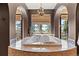 Luxurious spa-like bathroom with large soaking tub, arched entryways and private balcony access at 8417 High Ridge Ct, Castle Pines, CO 80108