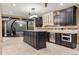 Modern kitchen with dark wood cabinetry, a spacious island, and stainless steel appliances at 8417 High Ridge Ct, Castle Pines, CO 80108
