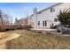 Expansive backyard with a circular patio, fenced perimeter, and mature landscaping at 1832 S Tamarac St, Denver, CO 80231