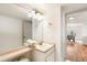 Well-lit bathroom featuring a large mirror, vanity with sink, and view to the dining area at 1832 S Tamarac St, Denver, CO 80231